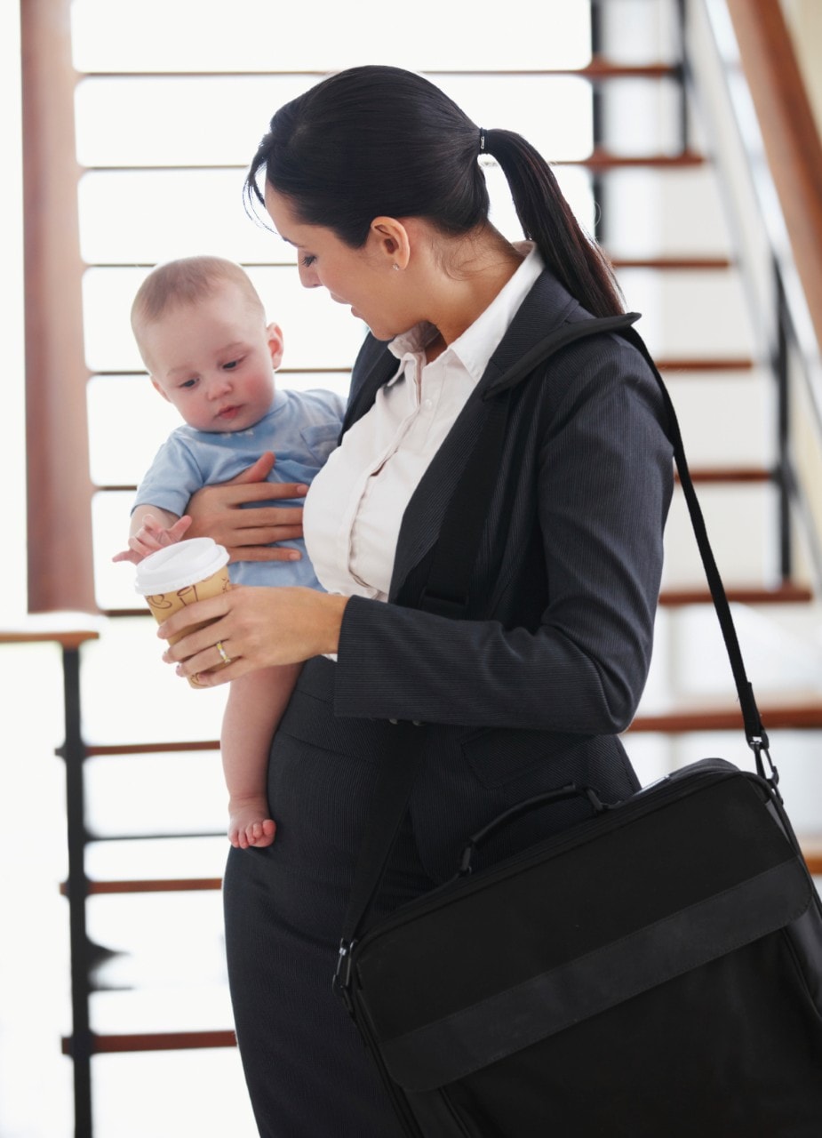 An office worker holds a child. Image: iStock