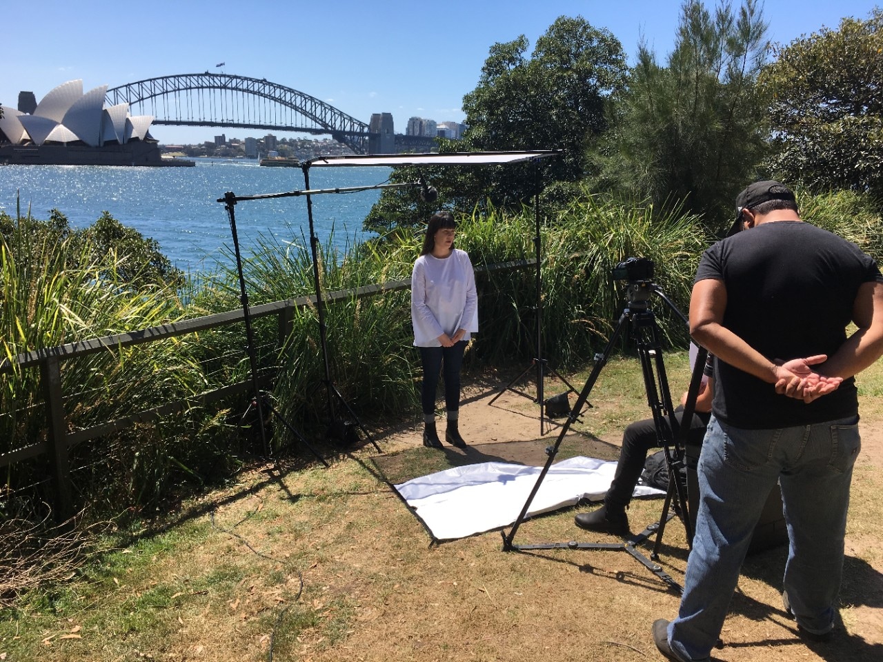 A photo of people recording video on Sydney Harbour.