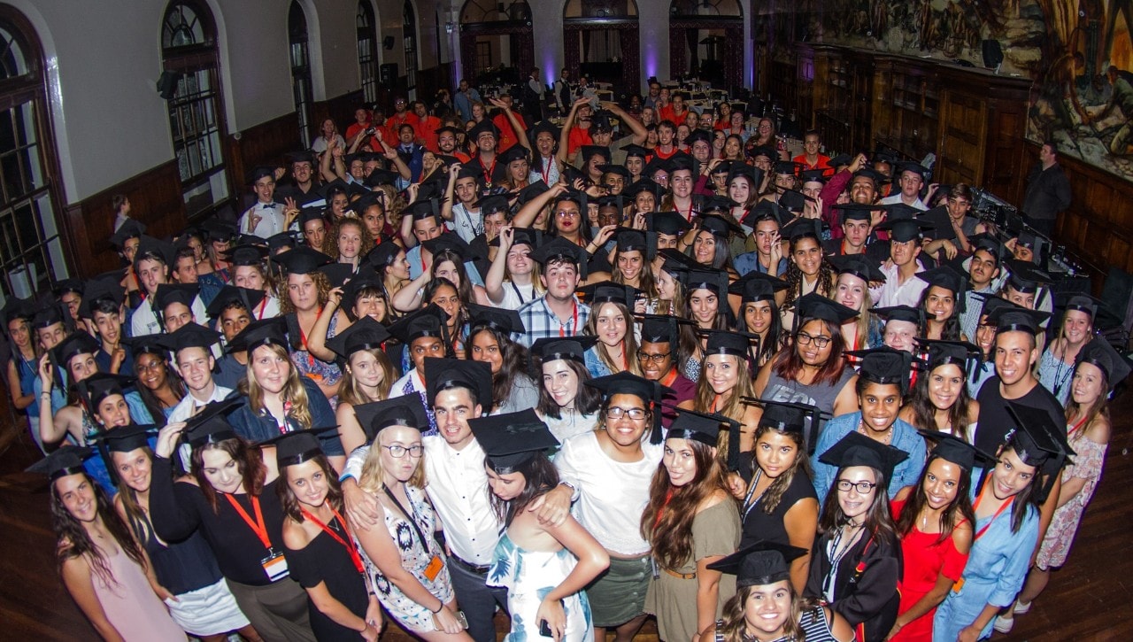 A photo of a large group of young people wearing academic caps.