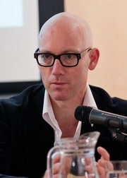 Profile image of the author - Professor Dirk Moses - sat at a microphone. 