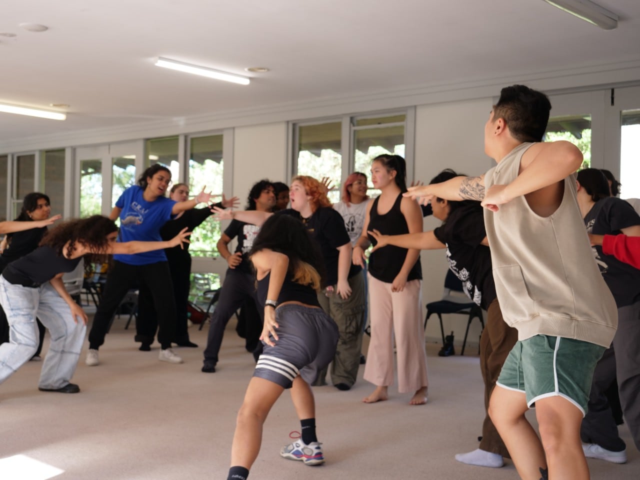 Students rehearsing an energetic group number with choreography