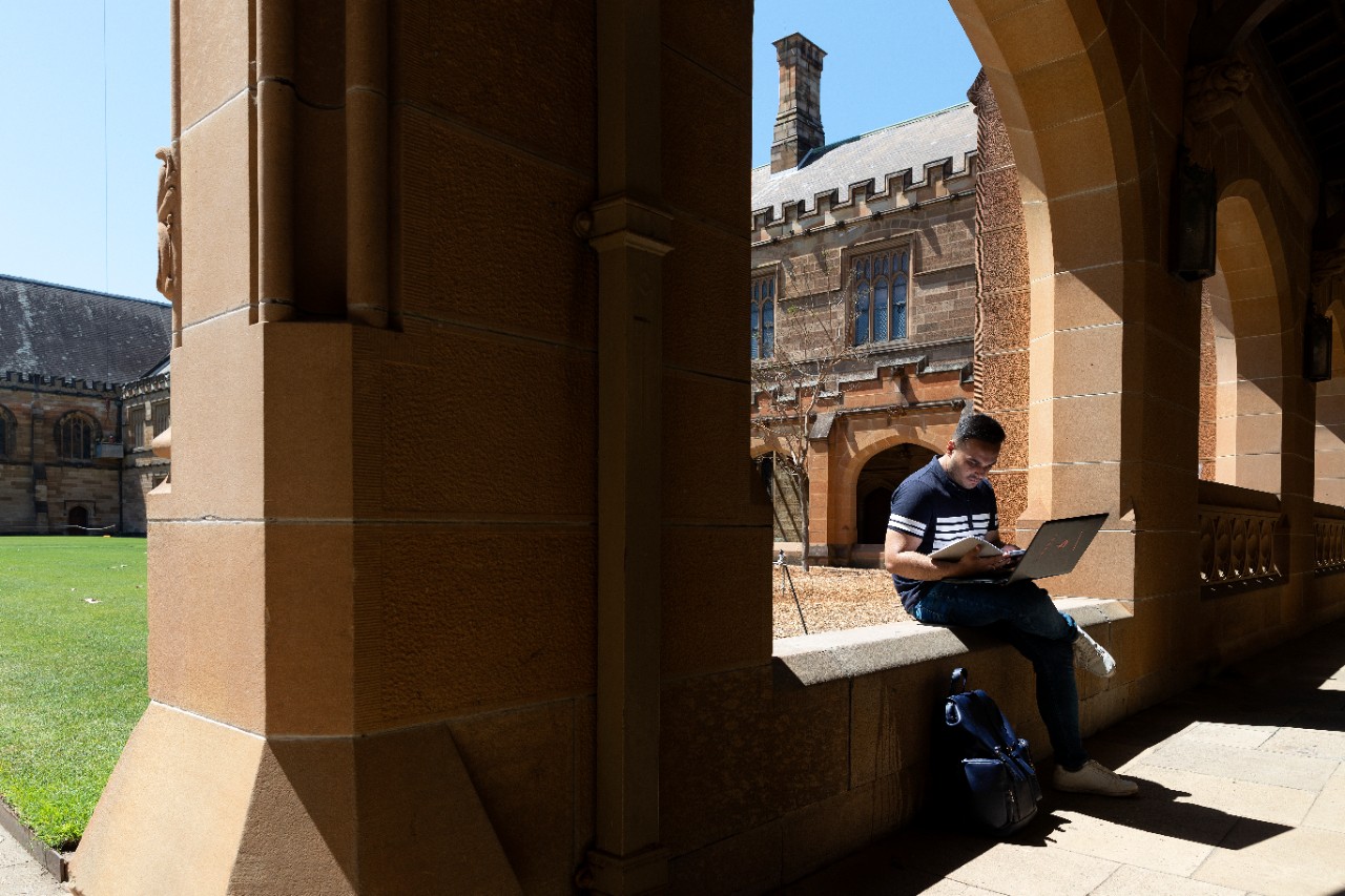 Student studying in the University of Sydney Quadrangle cloisters.