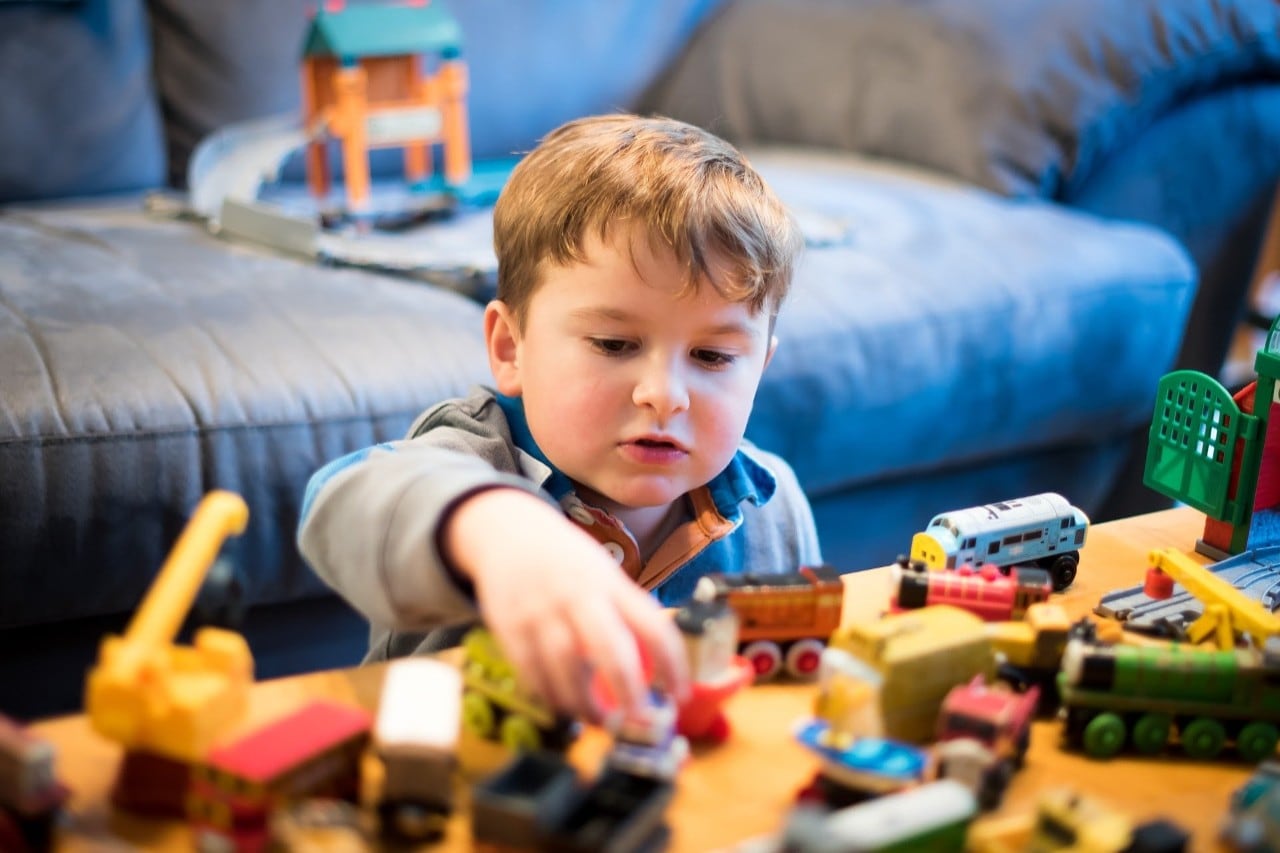 Photo of a boy playing with toy trains