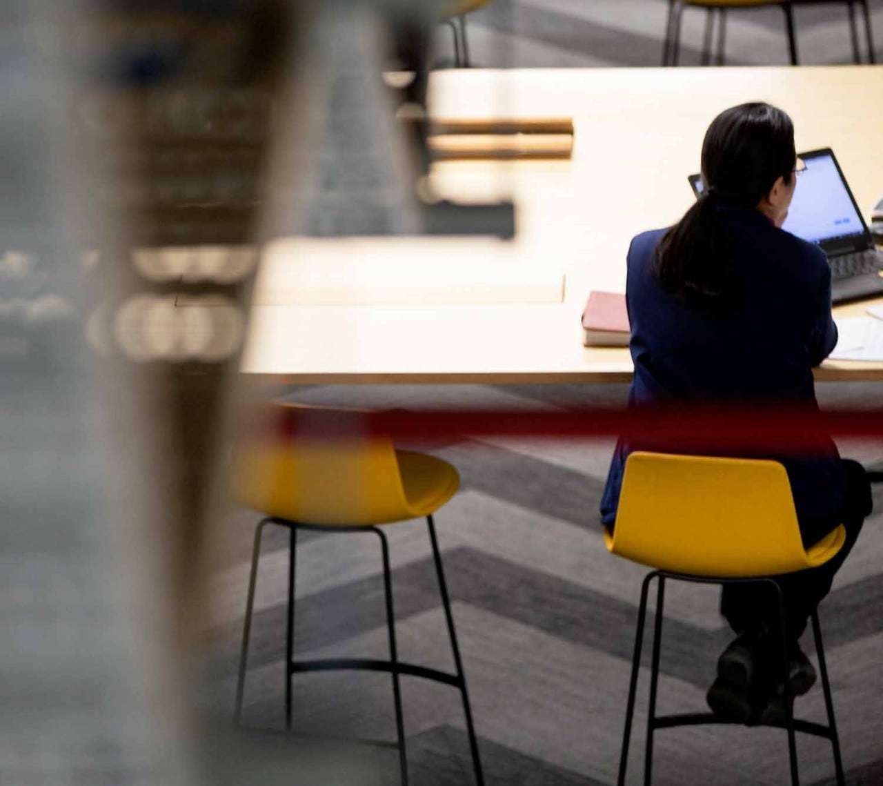 Student speaking to another person out of frame with an open laptop in front of them.