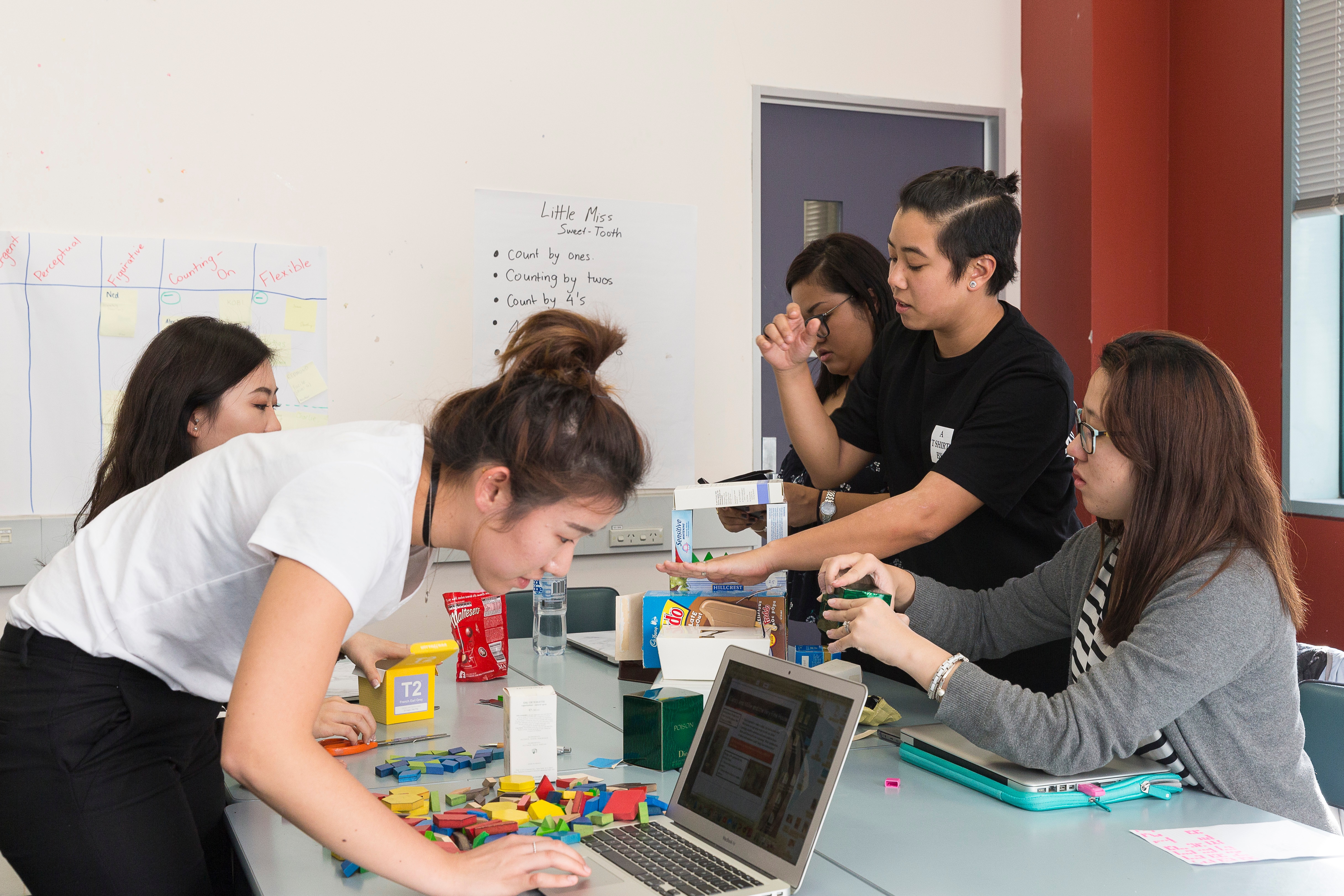 Students working around a table with their laptops