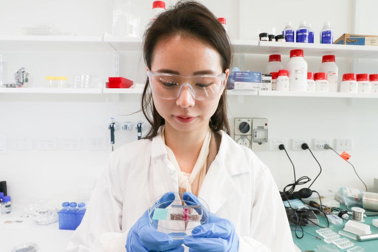 Dr Ann Na Cho holding biomedical dish in lab environment
