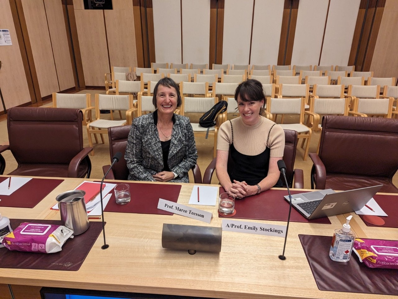 Maree Teesson (left) and Emily Stockings (right) giving evidence at the Senate inquiry into vaping. Both are looking at the camera and smiling. 