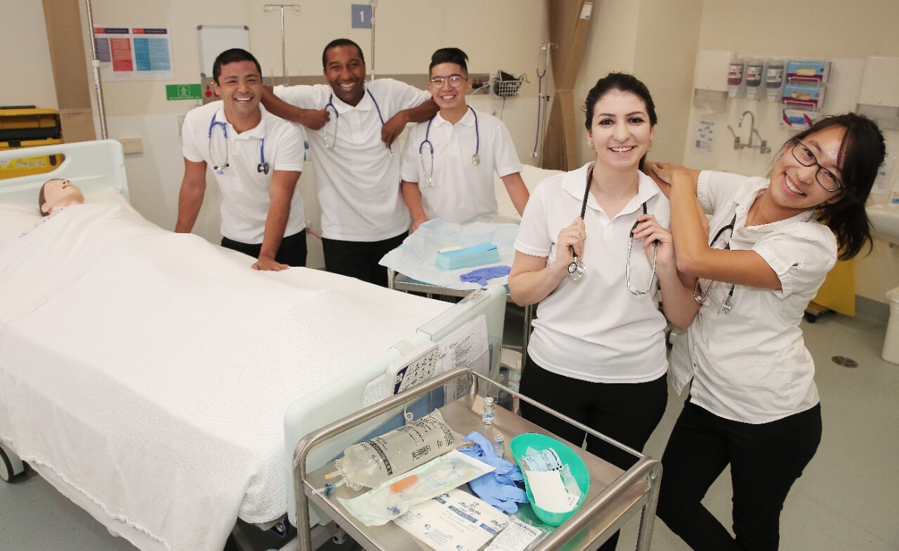 Picture of first class to complete Master of Nursing (Graduate Entry) at Westmead smiling in a simulation lab.