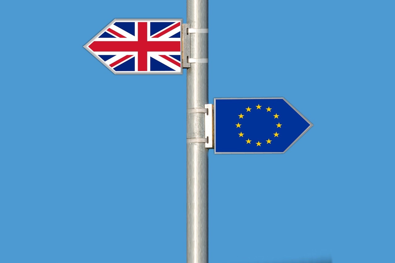 Signs of UK and EU flags pointing in opposite directions