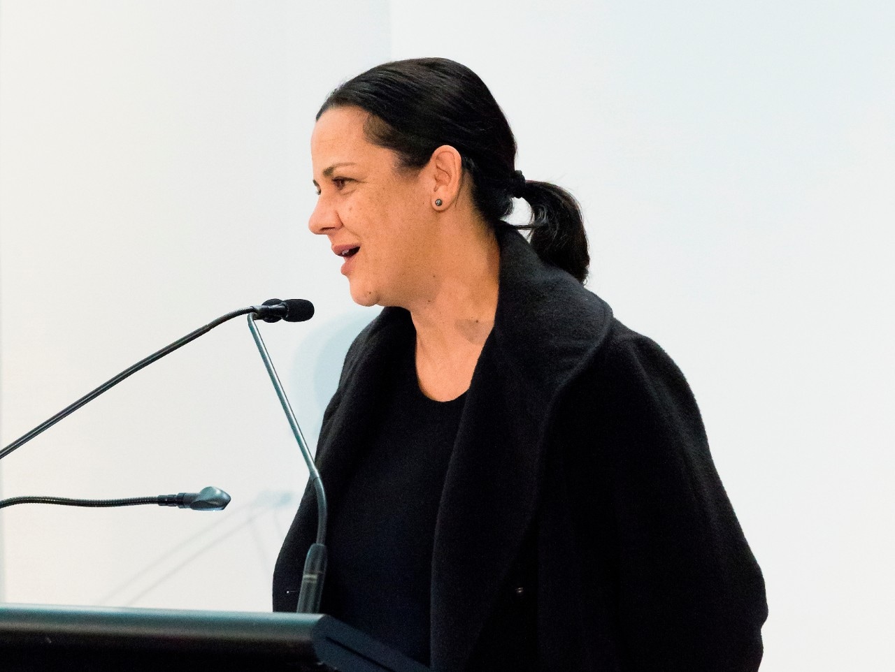A photograph of Hetti Perkins speaking at a microphone.