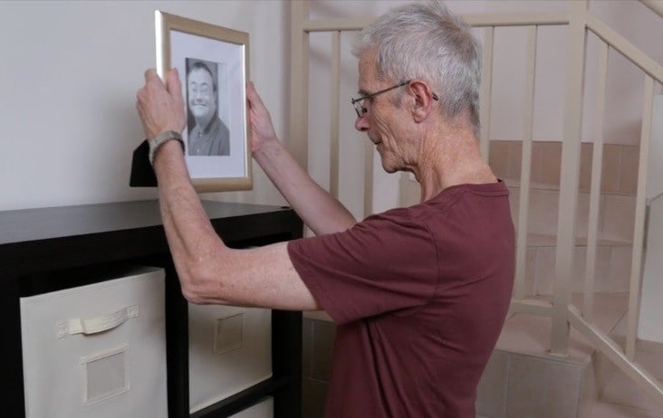 Older man looks at photo of friend who has passed away