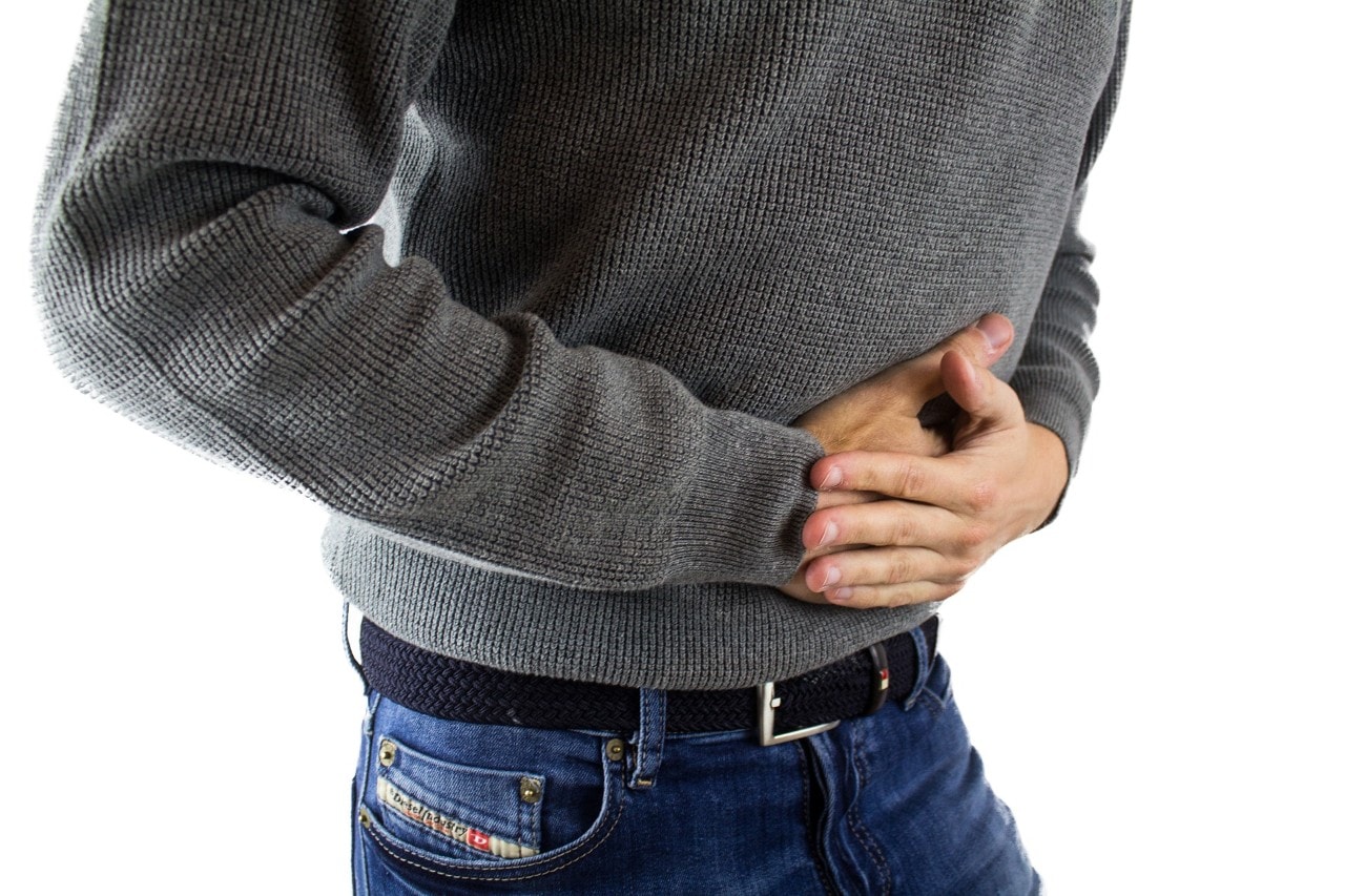 photo of a man holding his stomach in pain