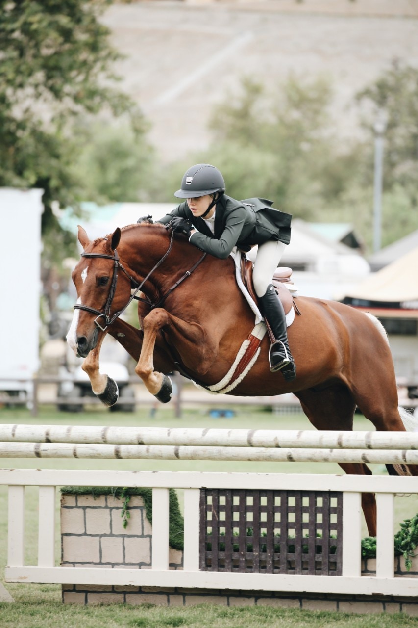 photo of a woman riding a horse in an equestrian event
