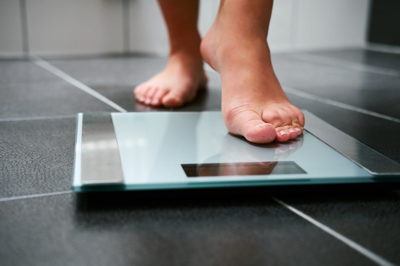 Person stepping onto bathroom scales