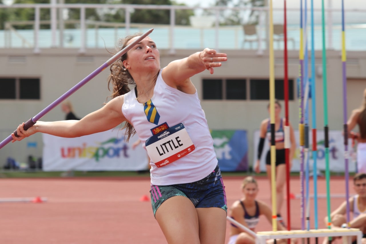A woman in a Sydney Uni Sport uniforn prepares to throw a javelin.
