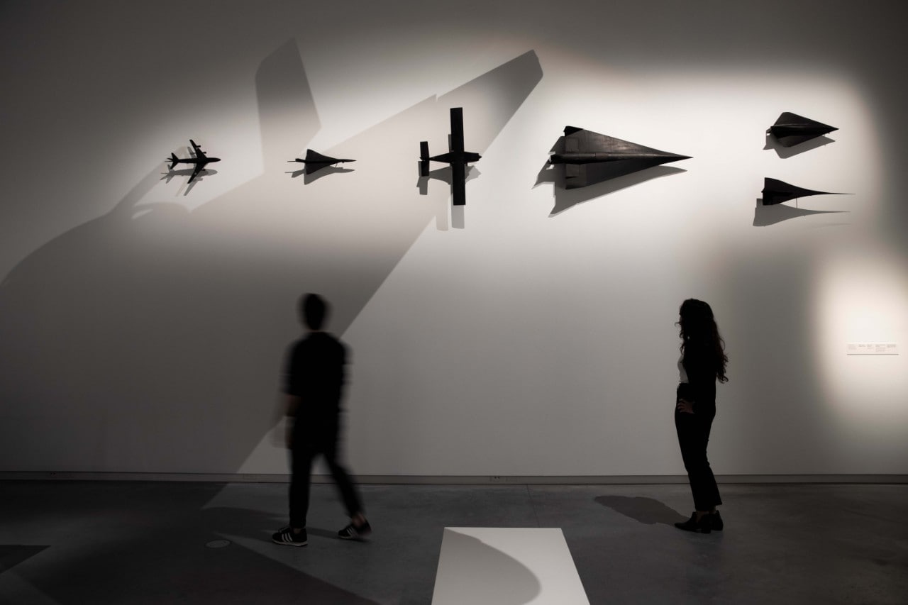 A woman looking at model planes on an exhibition wall