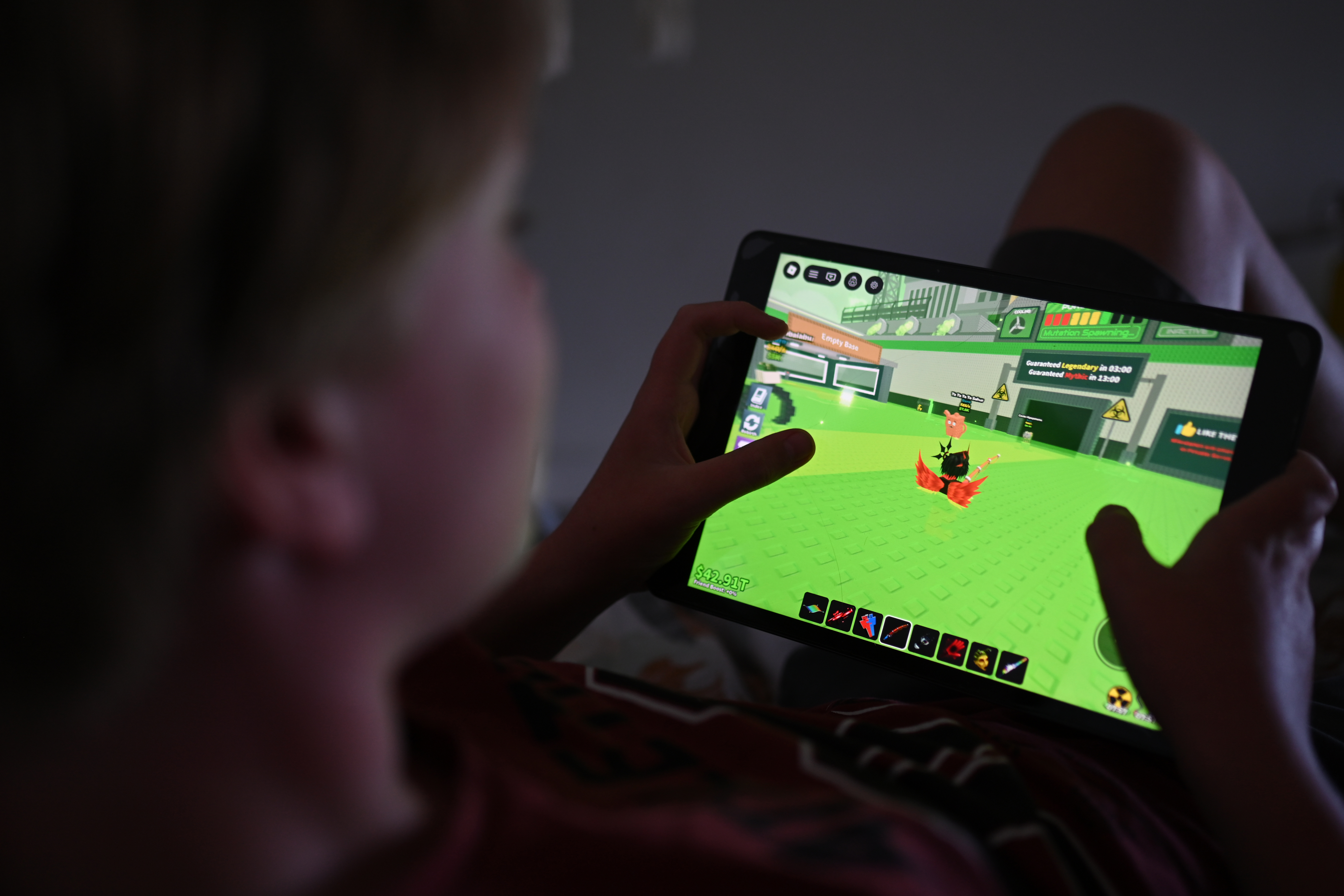 A young boy plays a game on his device in Sydney