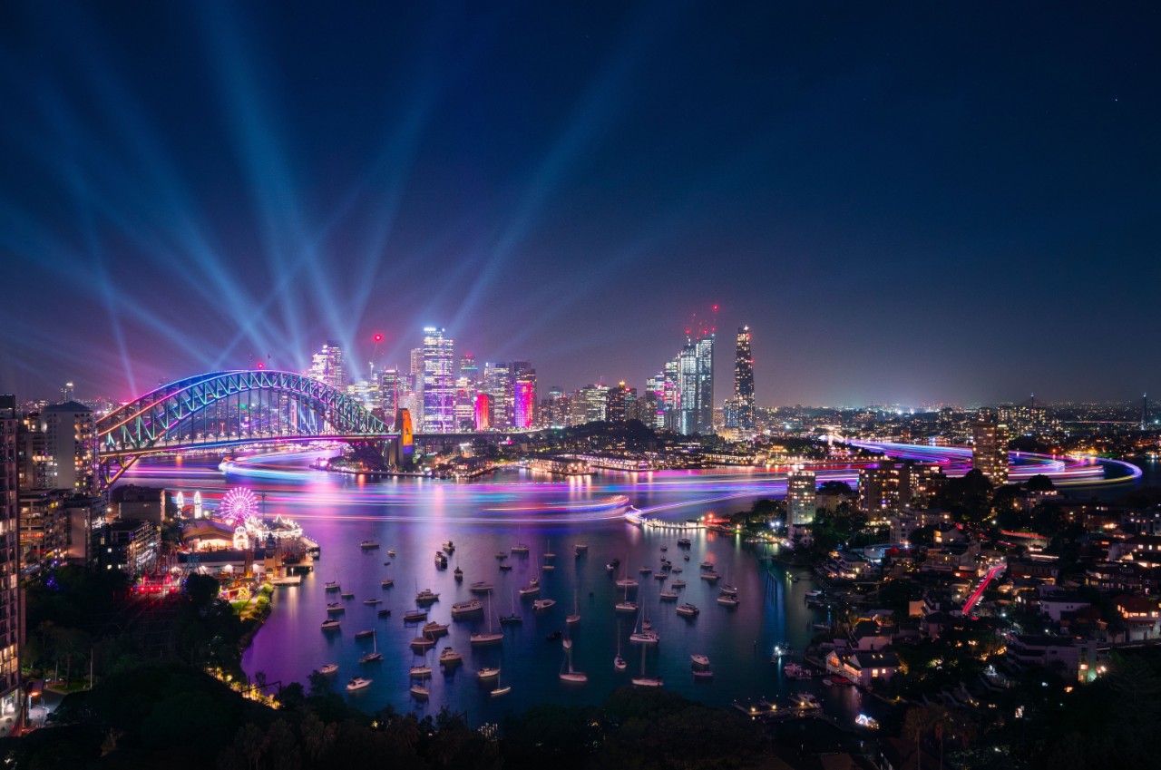 View of Sydney overlooking the harbour and Harbour Bridge in the evening with Vivid lights