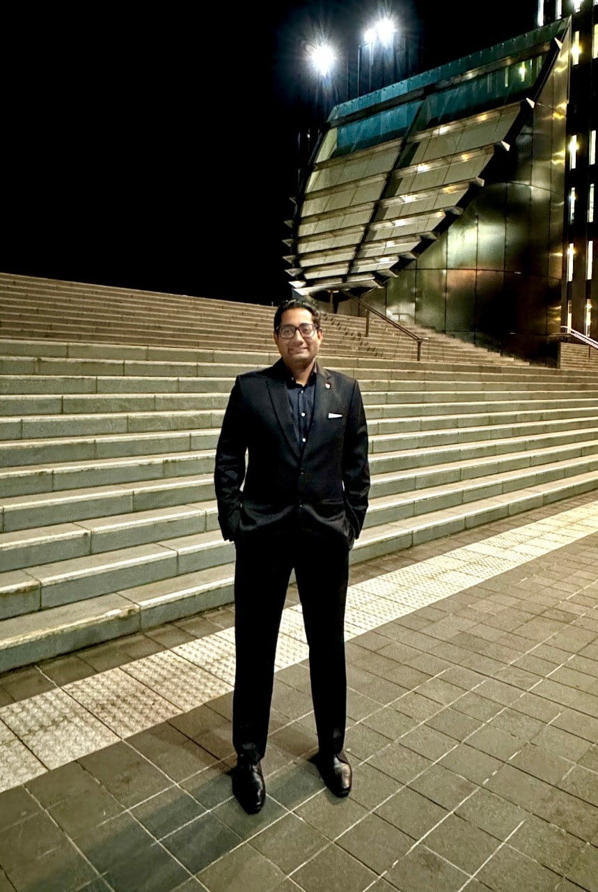 Ravi Prakash Vyas standing outside of the Sydney Law School at night