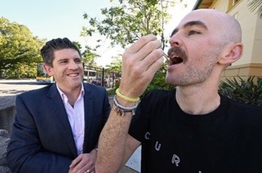 Dr Philip Mosley, left, supervises as Tourette syndrome patient Chris Wright takes  a dose of the medicinal cannabis that he says has changed his life. [Credit: Wesley Research Institute]