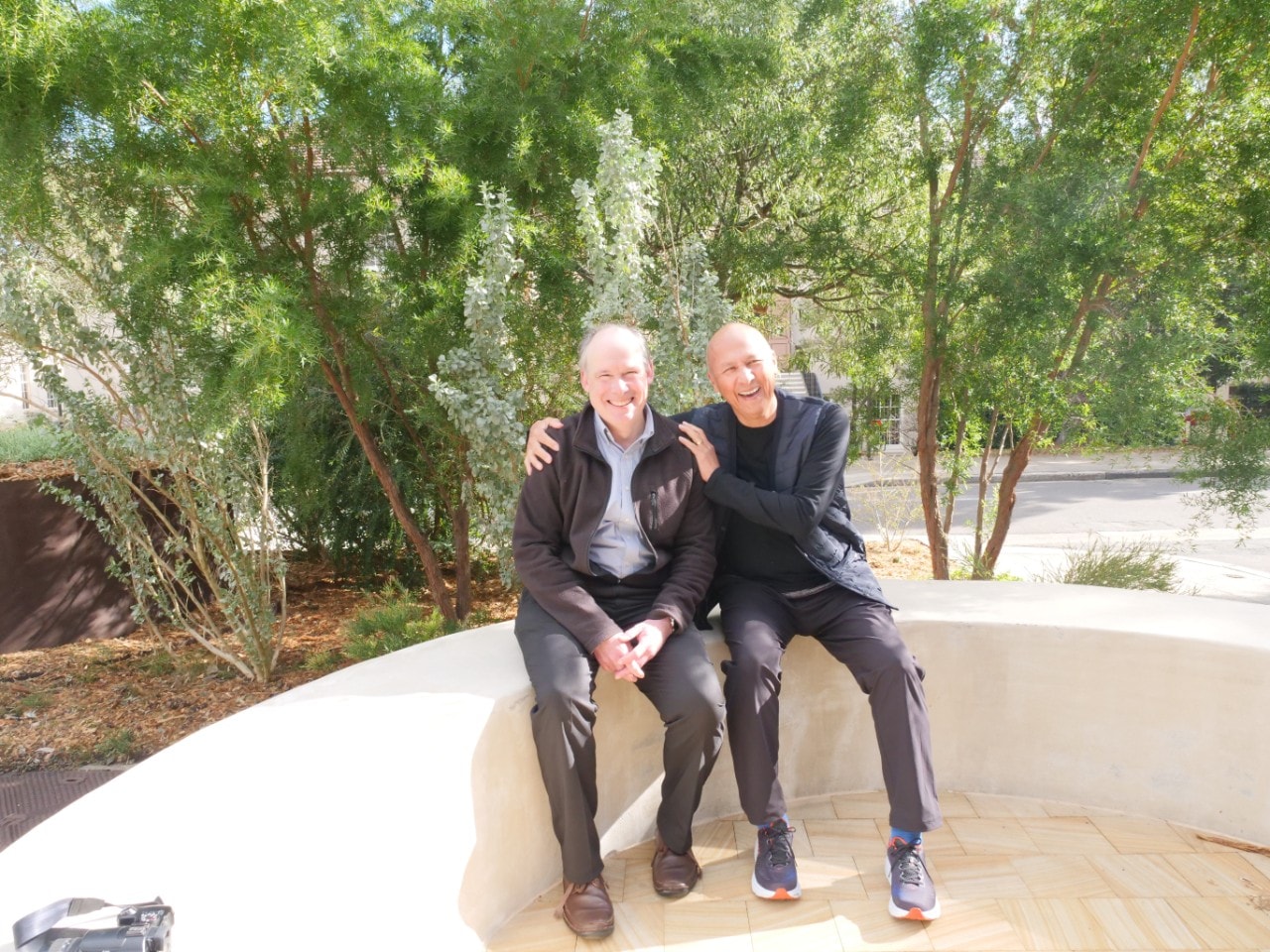 two men standing together outside a building with the words Power Institute