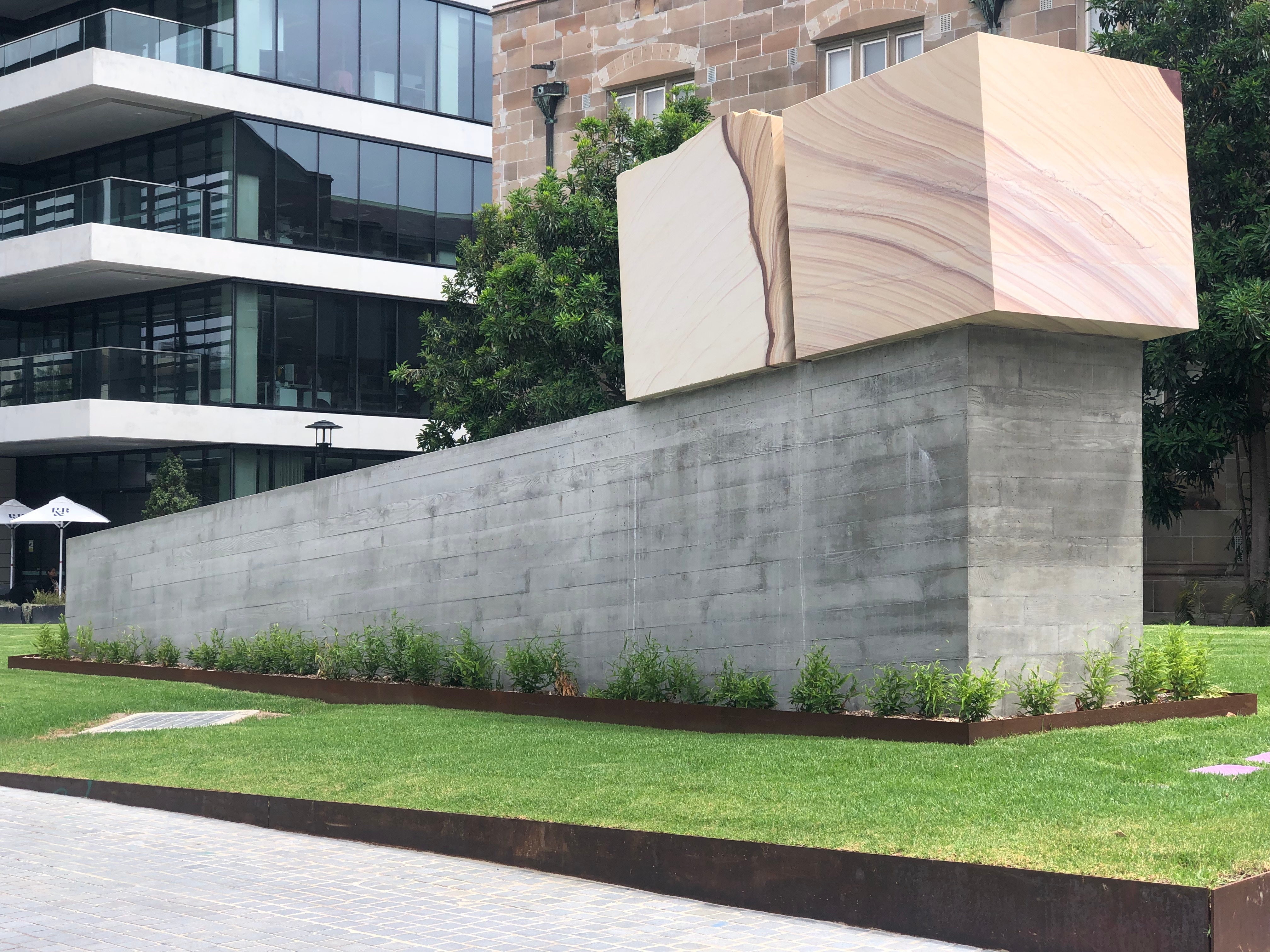 Image of Spine 2 sandstone block resting on concrete wall