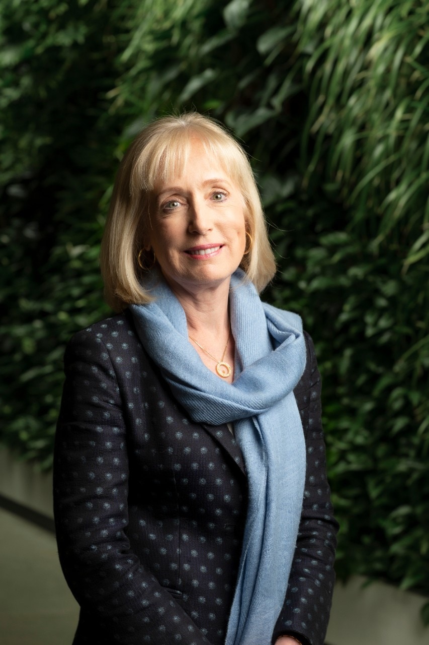 Chancellor Belinda Hutchinson in front of a wall of green plants