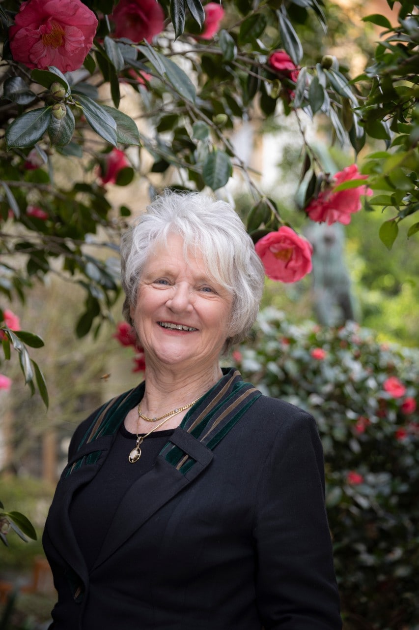 Marian Haire in front of pink flowers