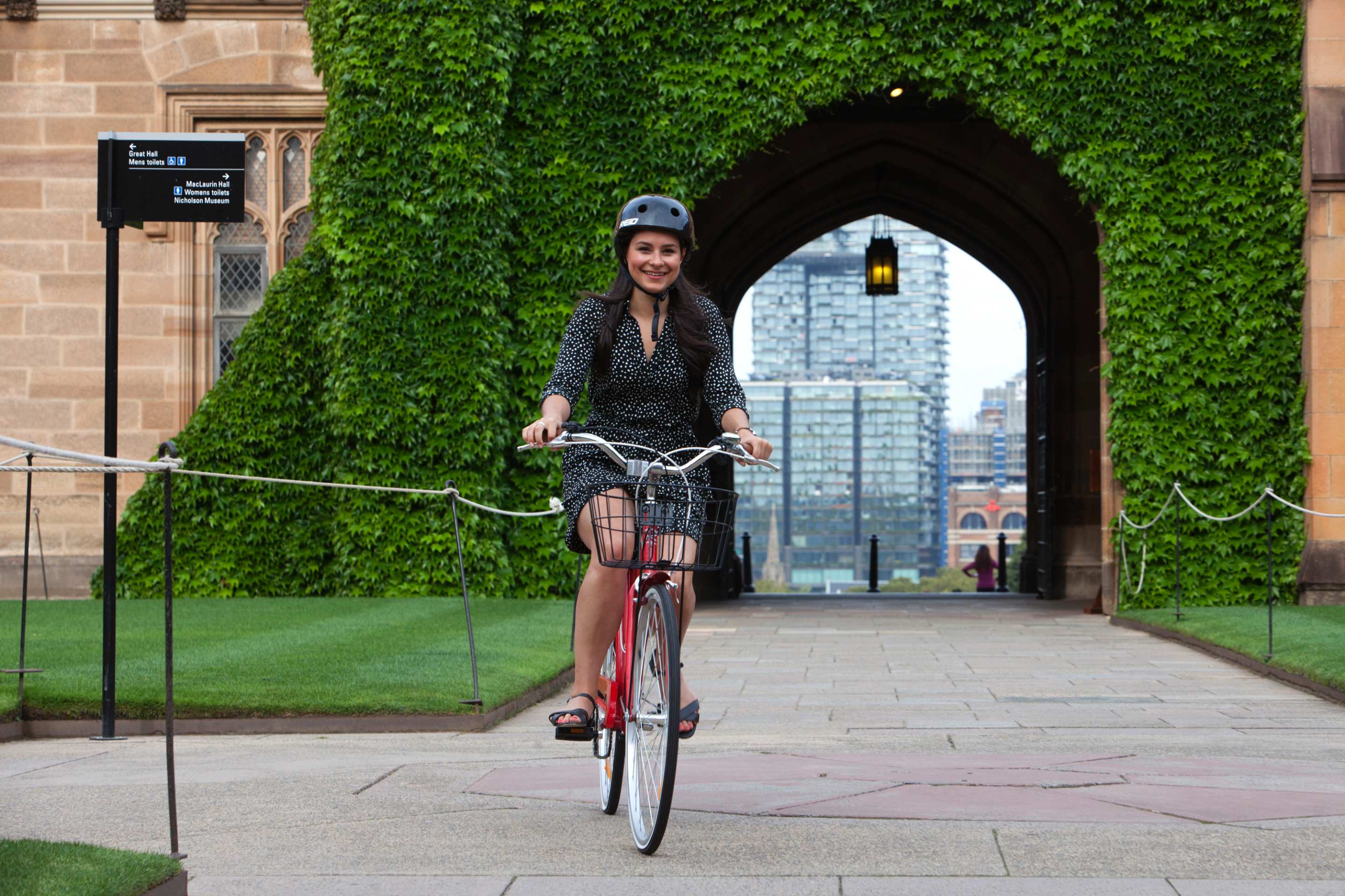 student on a bike with archway in background