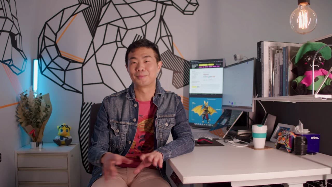 Dr Xavier Ho sitting at his computer playing a video game.