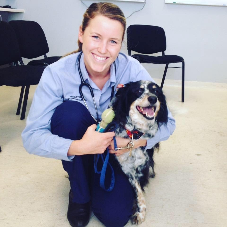 Rachel Booth crouched with a dog.