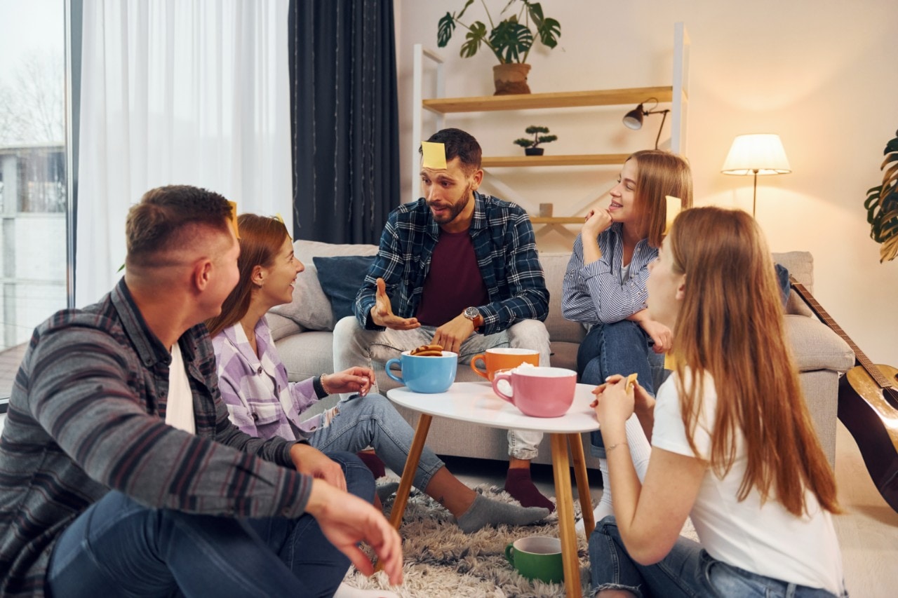 A group of people in a living room playing charades.