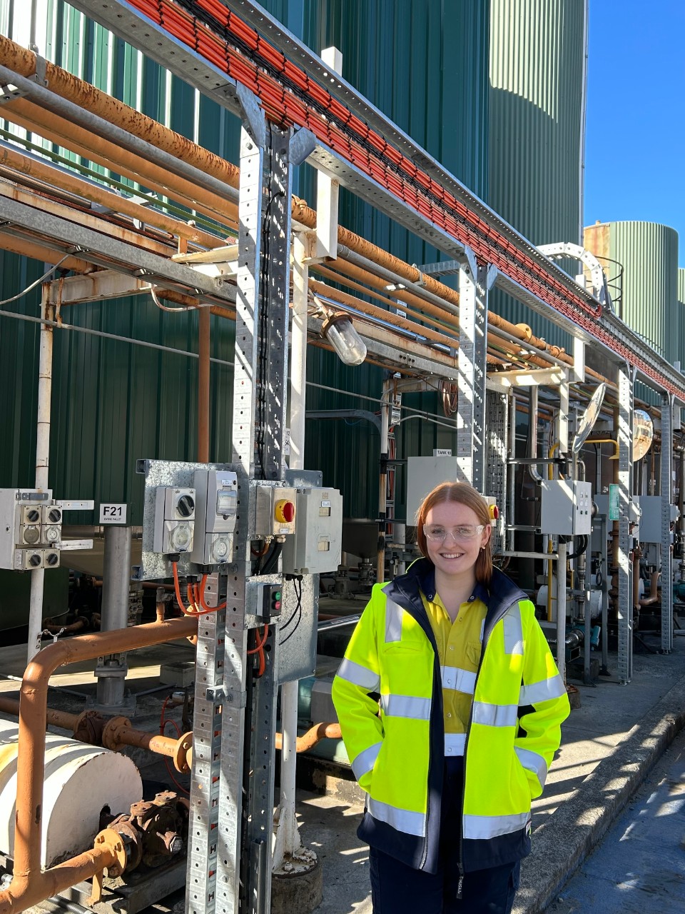 Laura Tighe stands in front of machine