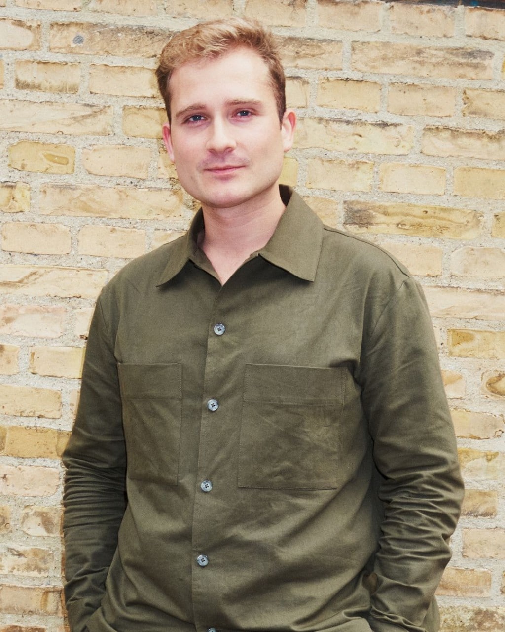 Young man dressed in a dark green button down