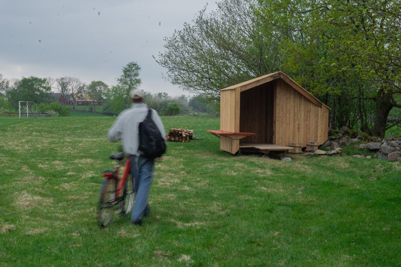 A man with a bicycle in a clearing next to the ArkRest rest stop