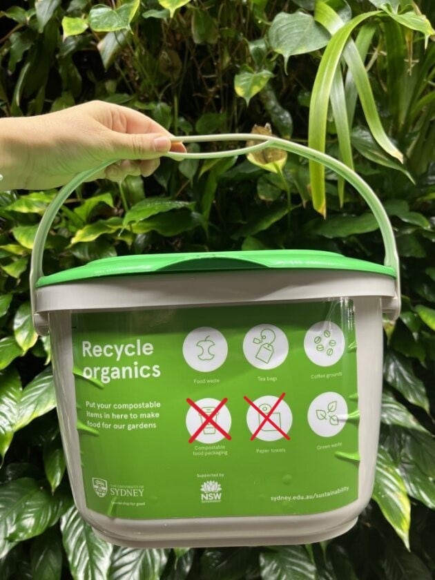 A small white bin with a green lid