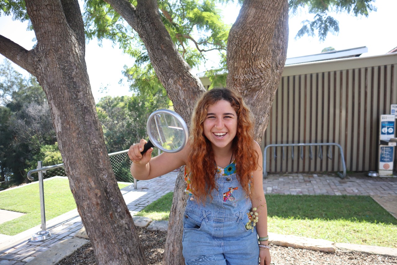 Photo of PhD student Amelie Vanderstock holding a magnifying glass