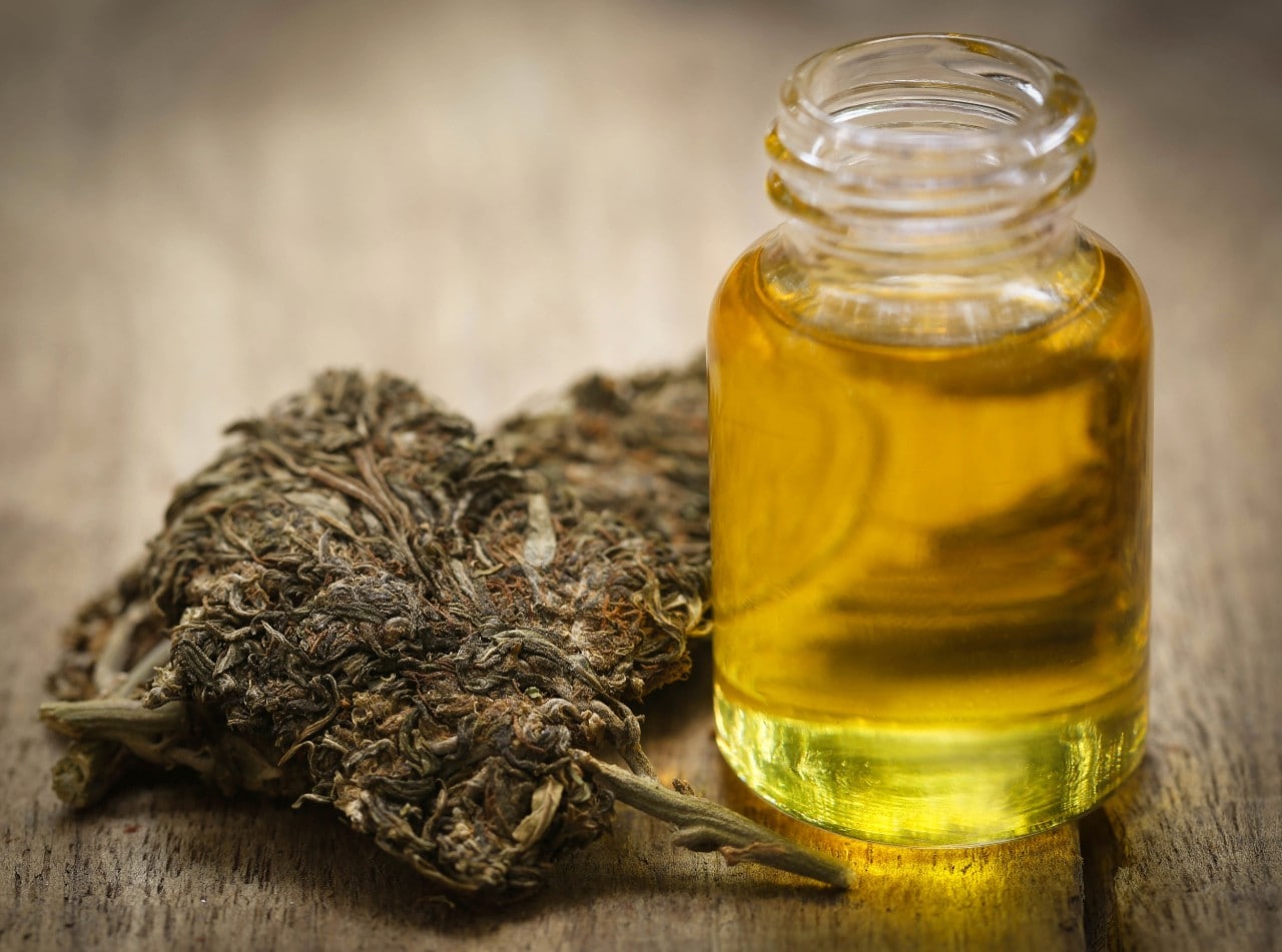 photo of a cannabis leaf and a bottle of cannabis oil